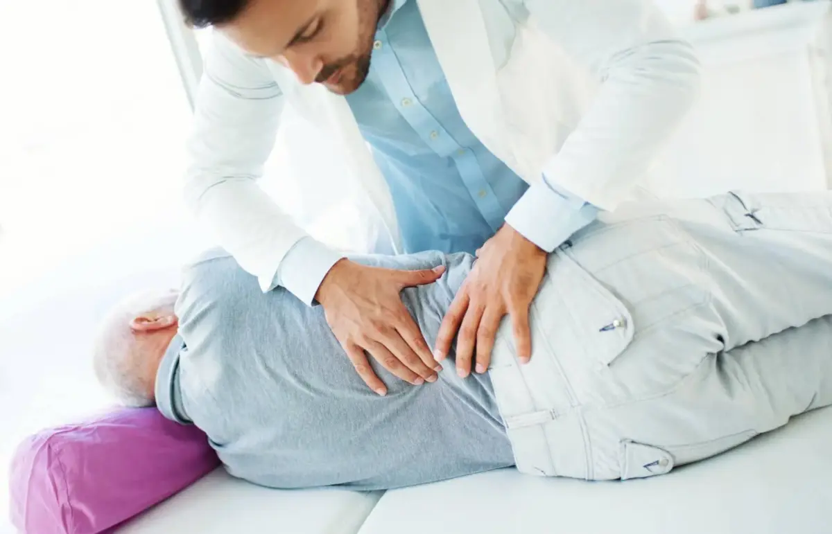 Doctor assessing a patient's lower back after a collision