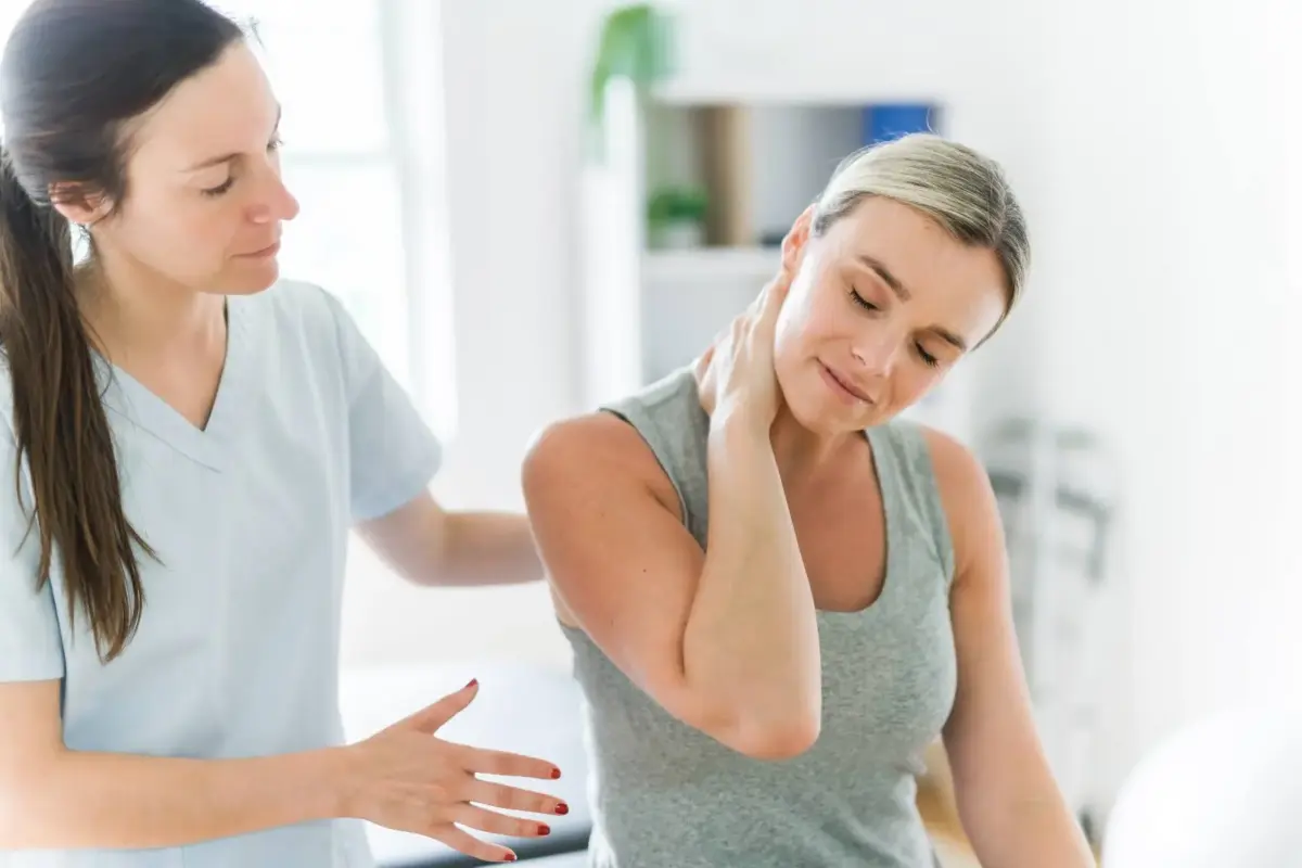Clinician assessing a patient's neck pain during a work injury exam